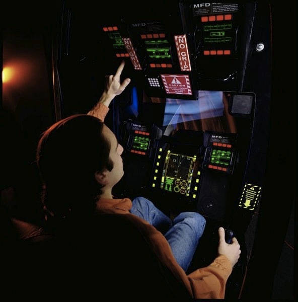 Person operating game controls in pod